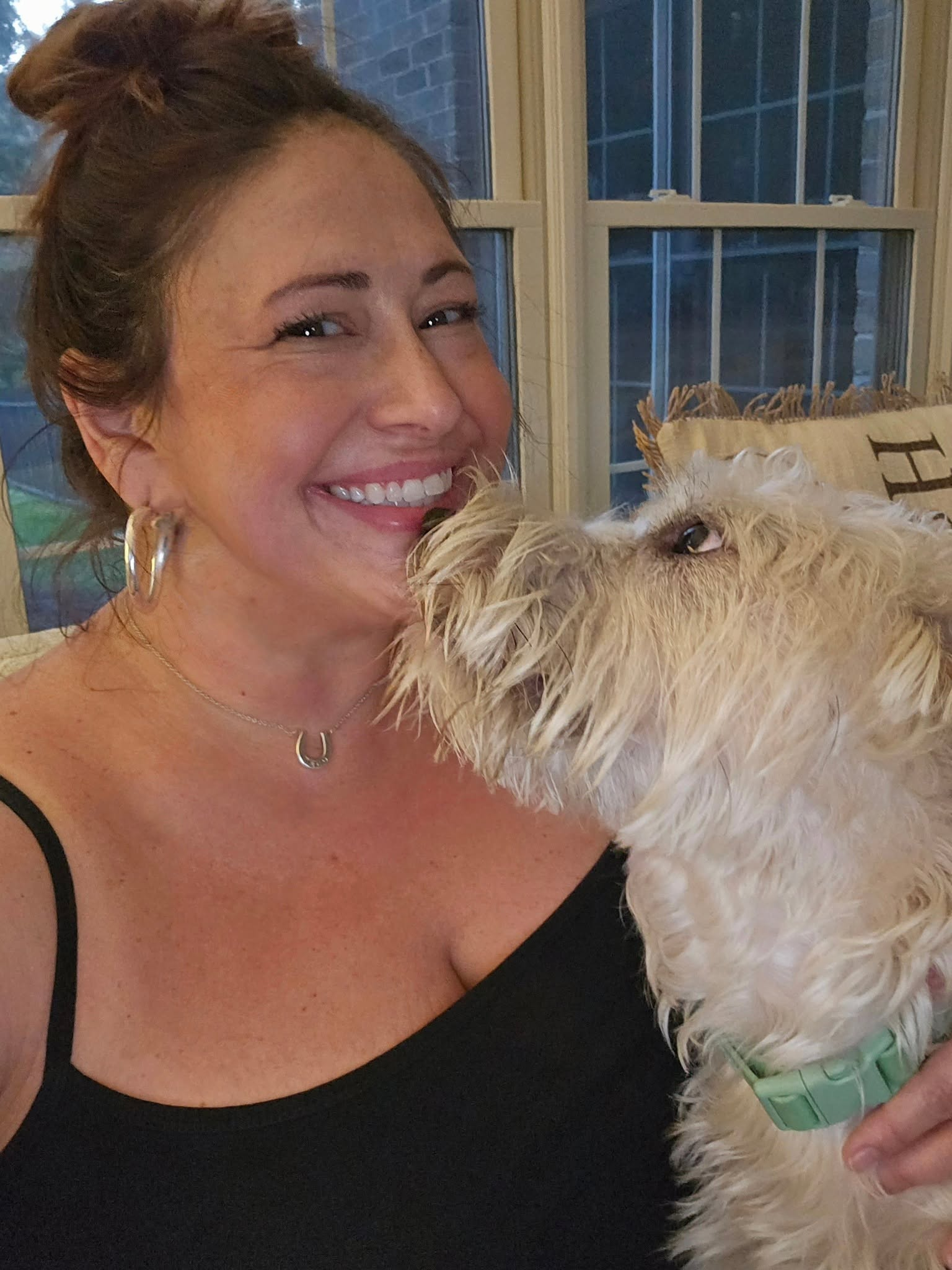 Julie laughing with a happy terrier