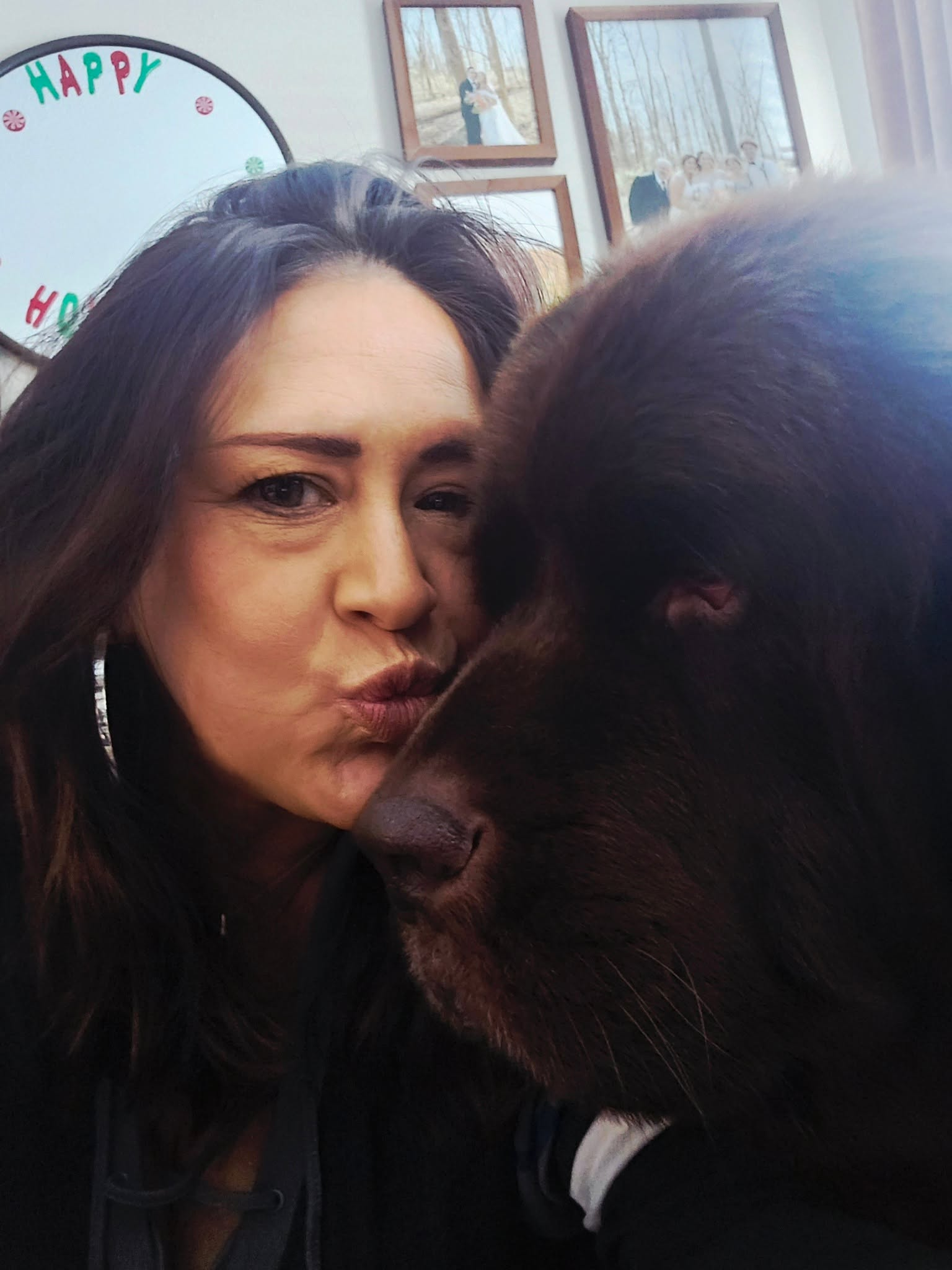 Julie giving a big brown dog a kiss